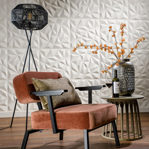 Modern living room with a brown armchair, decorative lamp, and side table with a bottle and glass against a #d wall panel 'Puck'.