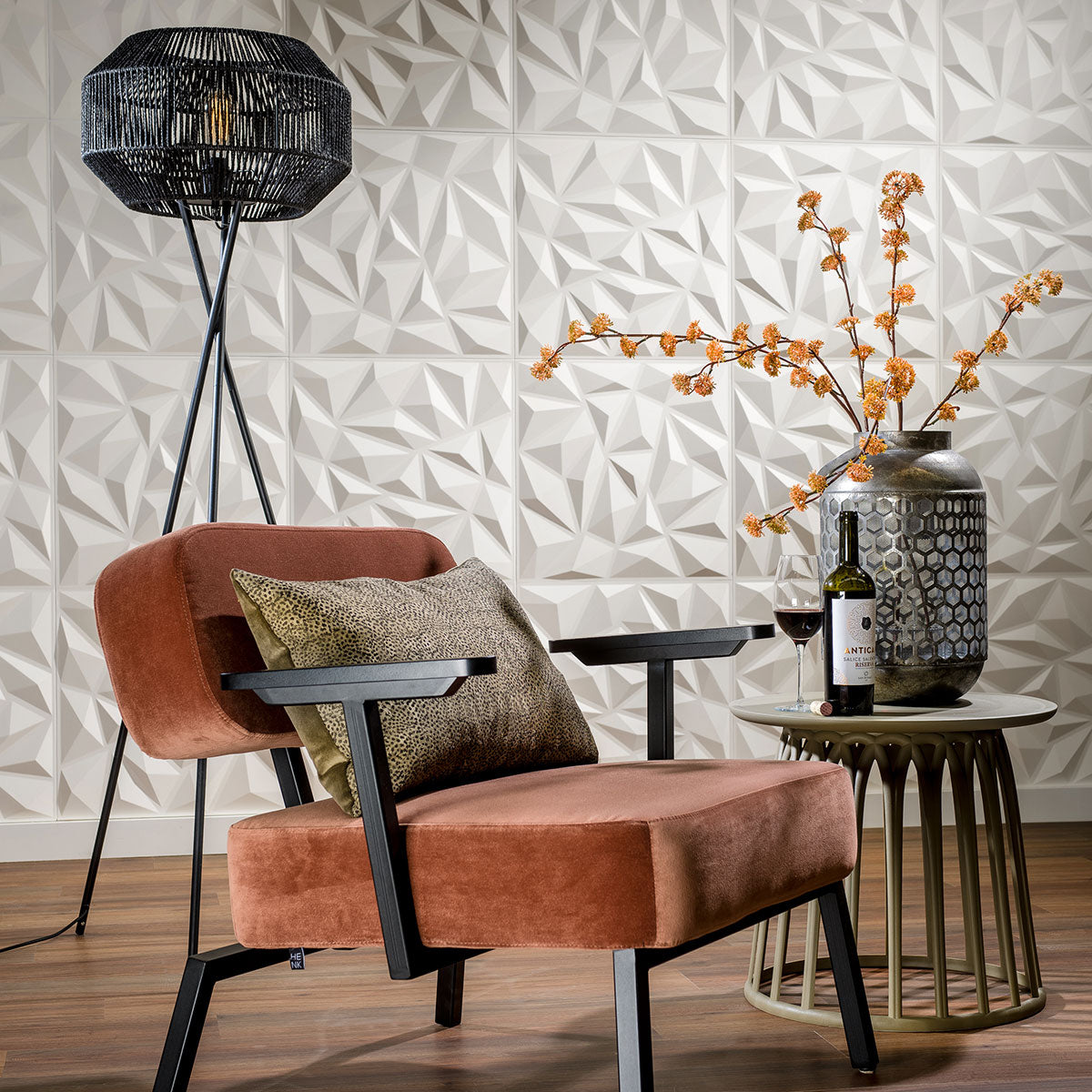 Modern living room with a brown armchair, decorative lamp, and side table with a bottle and glass against a #d wall panel 'Puck'.