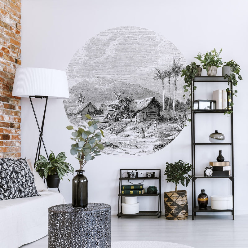 Living room with a Wallpaper circle with the landscape of Guadeloupe, shelves with decor items, and a lamp.