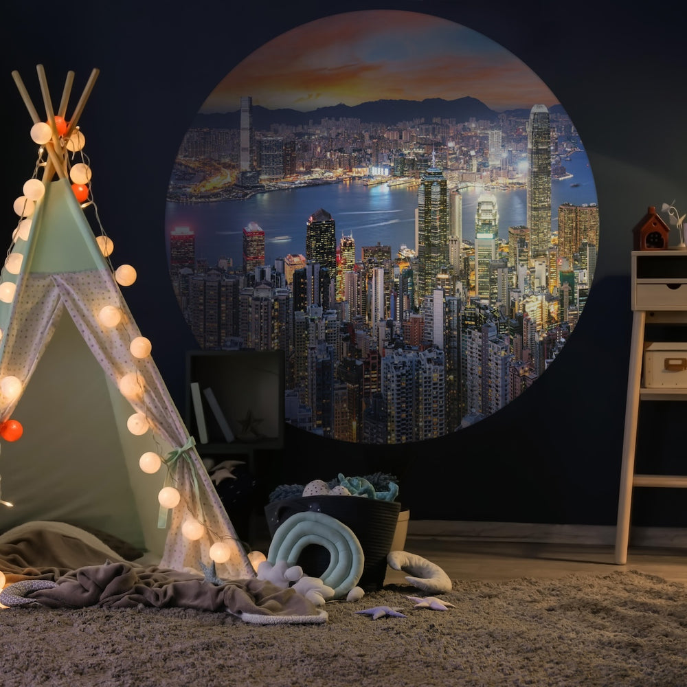 Children's room with a teepee, fairy lights, and a Wallpaper circle with a skyline by night.